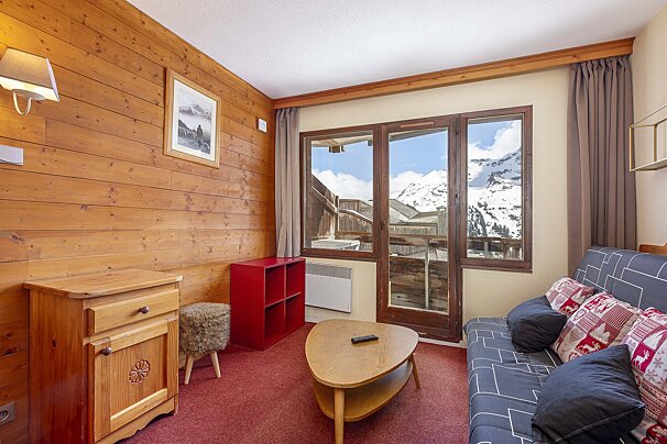 A living room with a red couch and a coffee table
