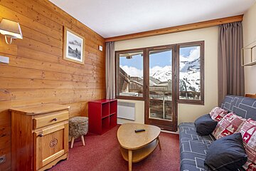A living room with a red couch and a coffee table