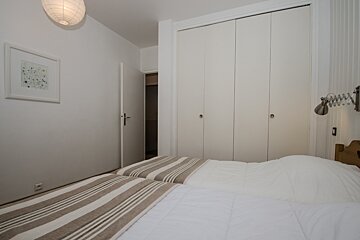 A bedroom with a bed and a picture on the wall