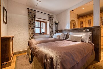 A bedroom with two twin beds and a window