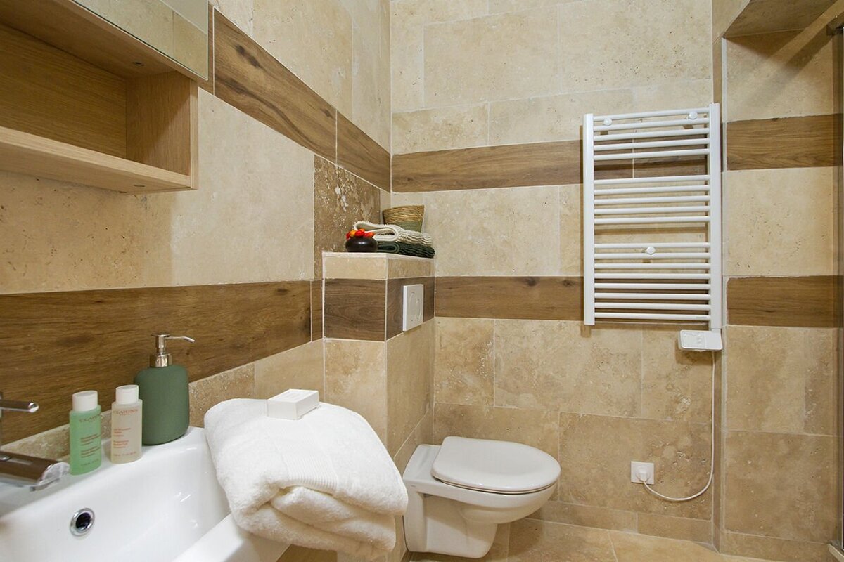 A bathroom with a toilet a sink and a towel