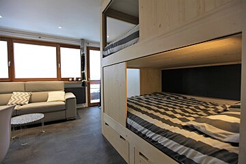 A living room with a bunk bed and a couch