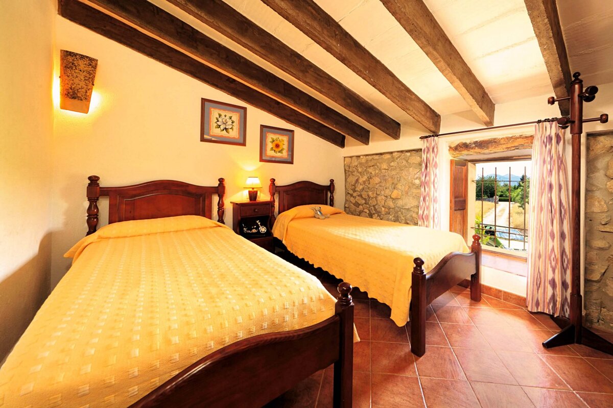 A bedroom with two twin beds and a window