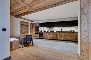 A kitchen with wooden cabinets and black counter tops