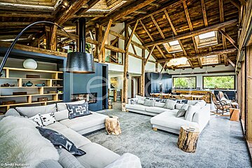 A living room with a couch that has a pillow with a cross on it