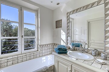 A bathroom with a large mirror and a window