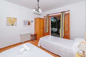 A bedroom with two beds and a mirror on the wall