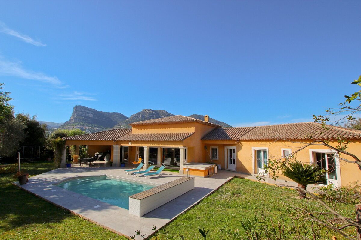 A large house with a swimming pool in front of it
