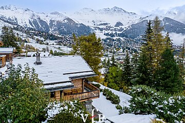 An aerial view of a snowy mountain landscape with the letter vb in the foreground