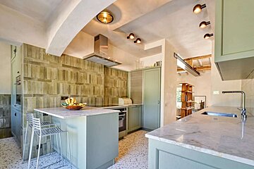 A kitchen with green cabinets and white counter tops