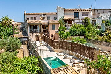A large house with a swimming pool in front of it