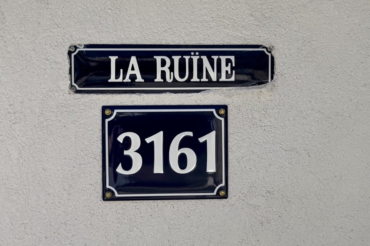 A sign that says la ruine next to a sign that says 3163