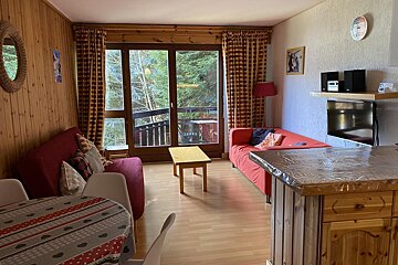 A living room with a red couch and a table