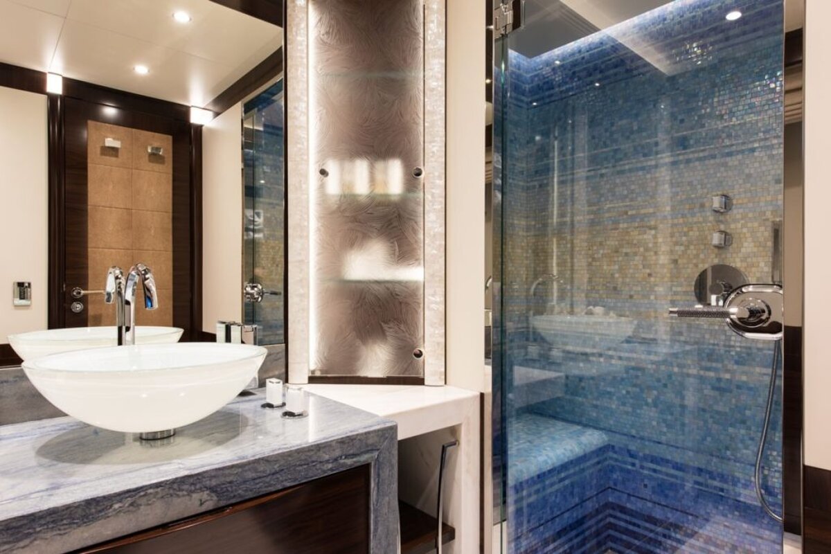 A bathroom with two sinks and a walk in shower