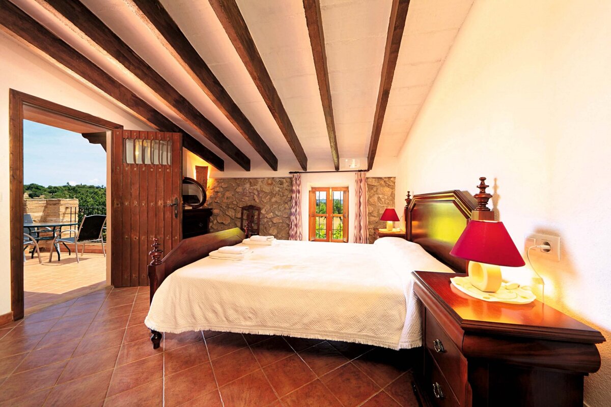 A bedroom with a large bed and a balcony