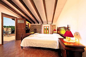 A bedroom with a large bed and a balcony