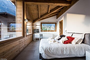 A bedroom with a large bed and a large window