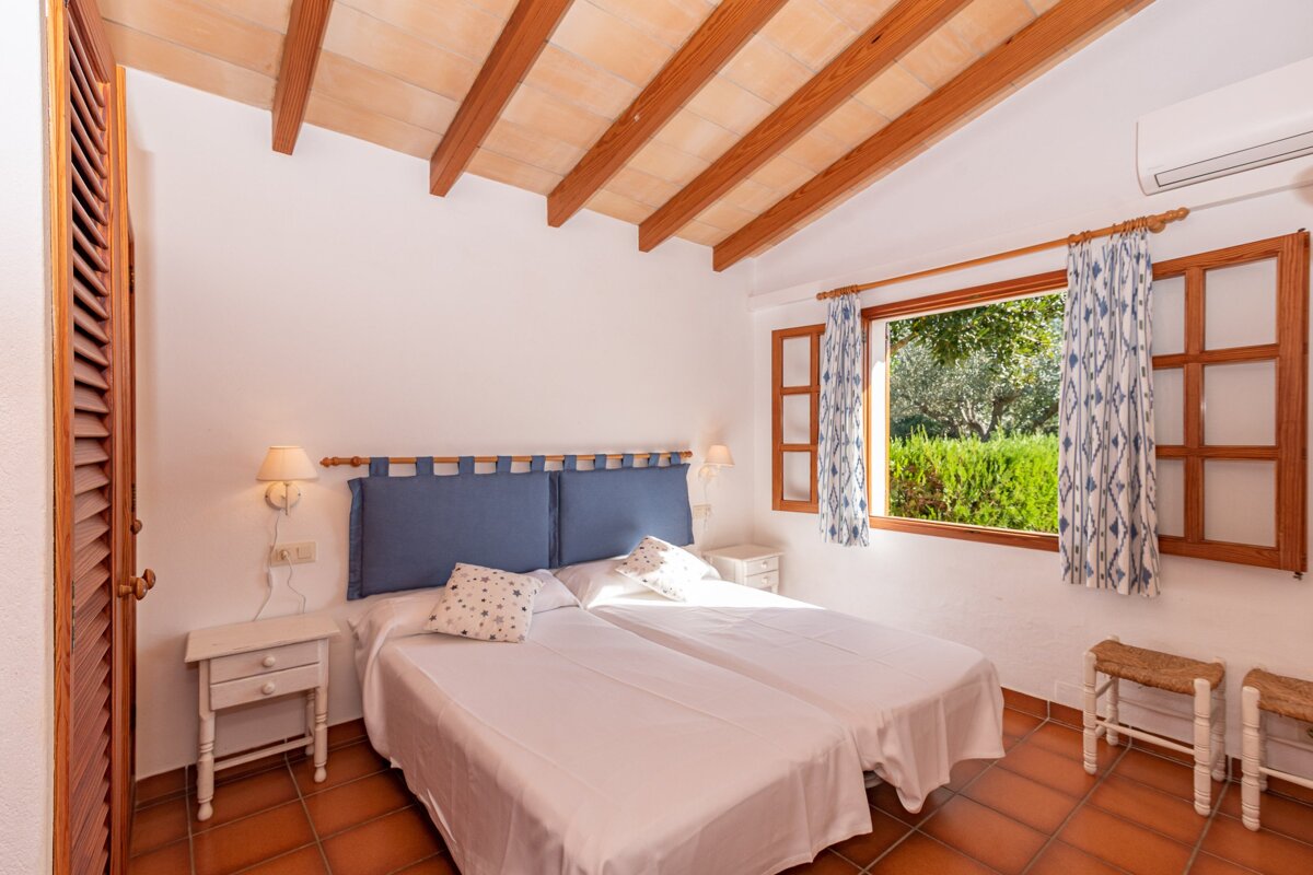 A bedroom with two beds and a window