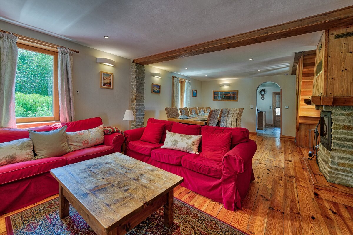A living room with two red couches and a wooden table