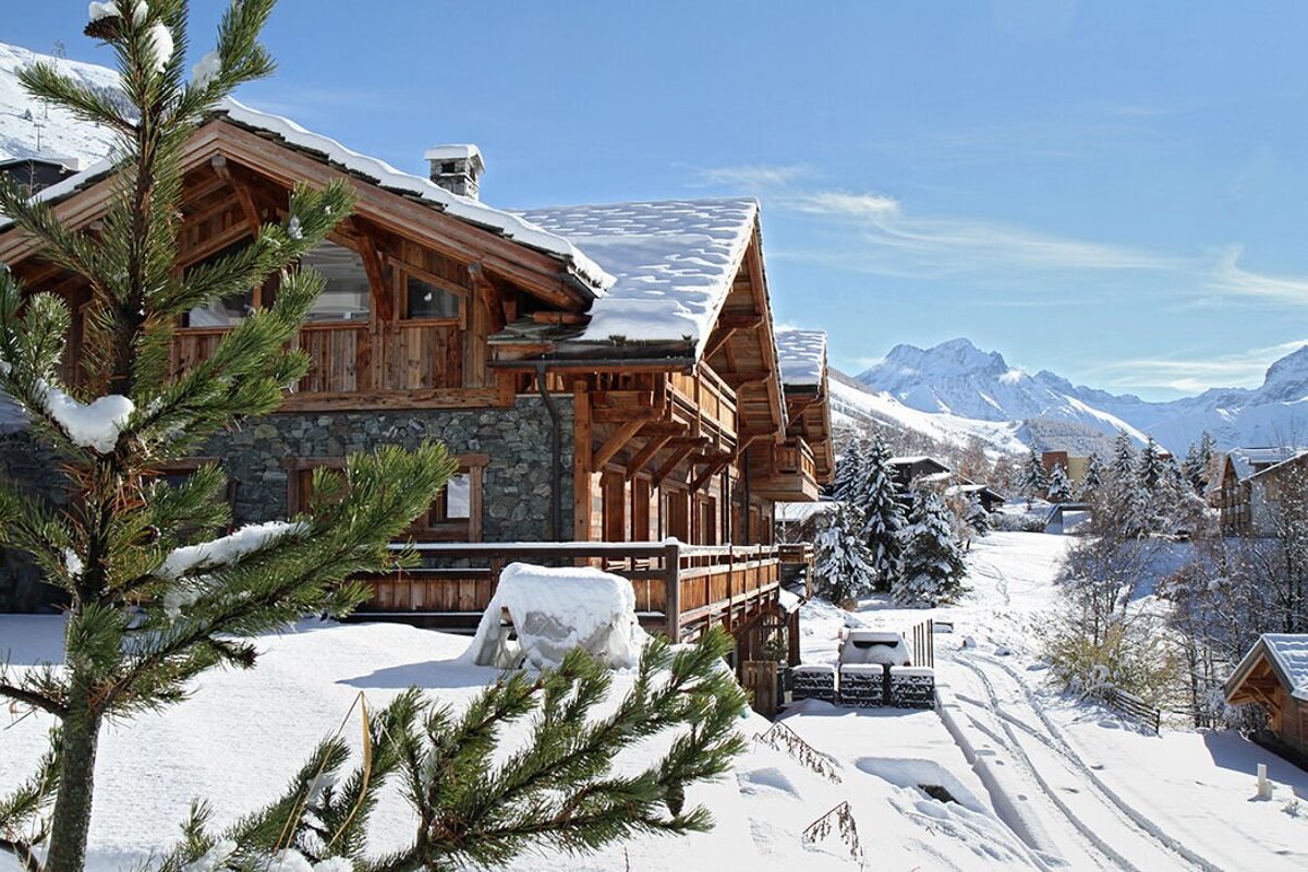 A snowy house with mountains in the background