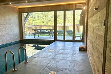 A swimming pool with a view of a deck and mountains