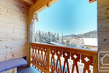 A wooden balcony with a view of snow covered mountains