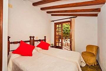 A bedroom with two beds and a yellow chair