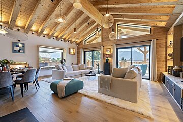 A living room with a vaulted ceiling and wooden beams