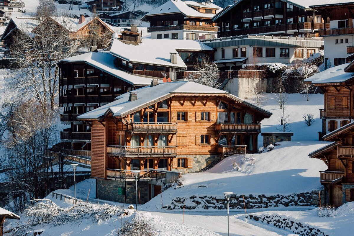 A row of snow covered houses with one that says ' a ' on it