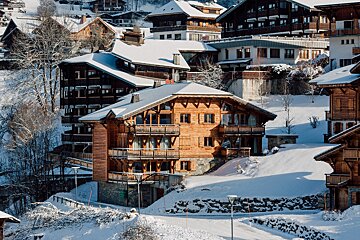 A row of snow covered houses with one that says ' a ' on it