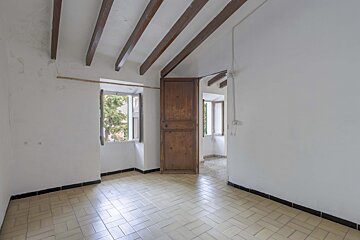 An empty room with a wooden door and a window