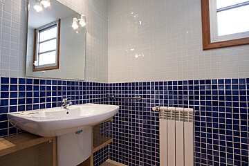 A bathroom with blue and white tiles and a sink