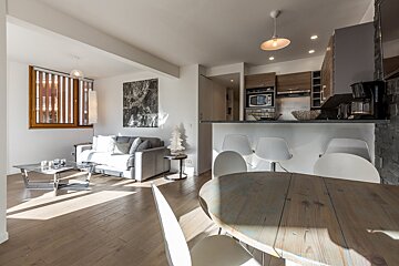 A living room with a couch and a table and chairs