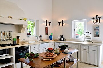 A kitchen with white cabinets and a wooden table