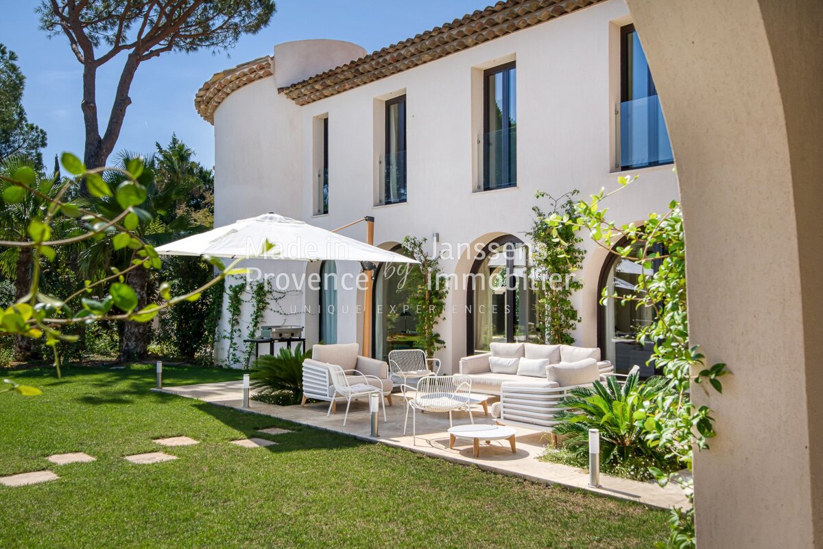 A white house with a white umbrella in front of it