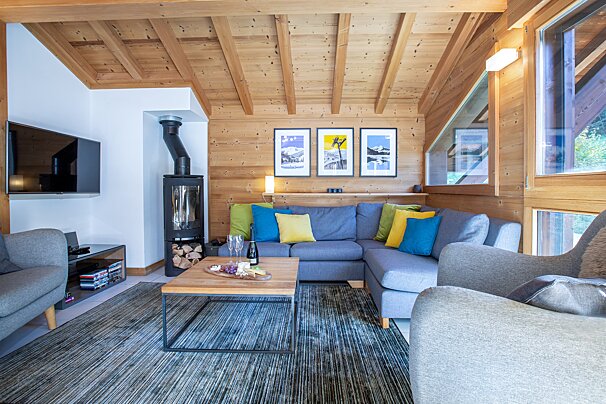 A living room with a couch and a table with a bottle of wine on it