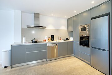 A kitchen with stainless steel appliances and grey cabinets