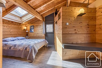 A bedroom with a bed and a sign that says alpine-property