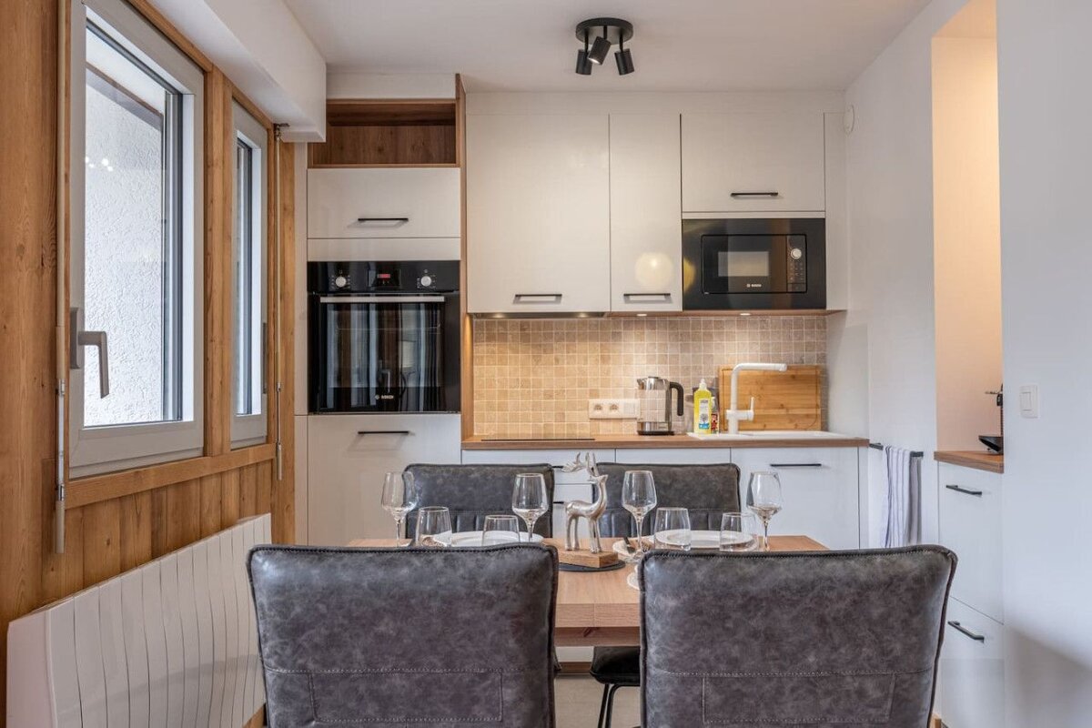 A kitchen with a table and chairs and a microwave