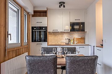 A kitchen with a table and chairs and a microwave
