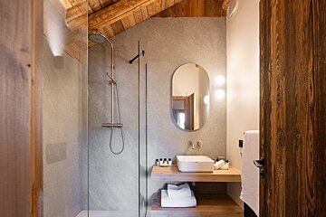 A bathroom with a walk in shower and a sink