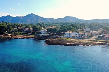 An aerial view of a coastline with mountains in the background