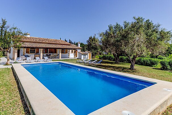 A large swimming pool in front of a house