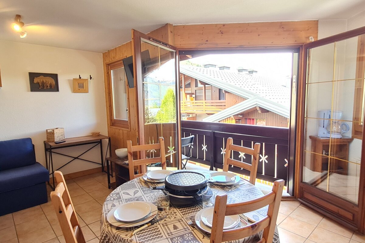 A room with a table and chairs and a balcony
