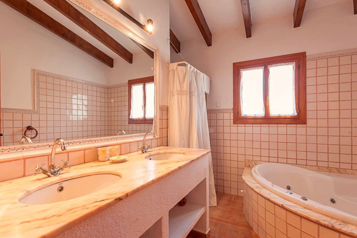 A bathroom with two sinks and a jacuzzi tub