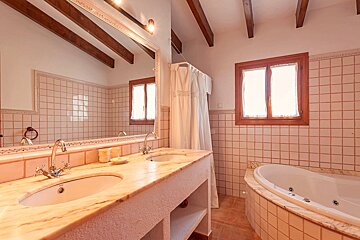 A bathroom with two sinks and a jacuzzi tub