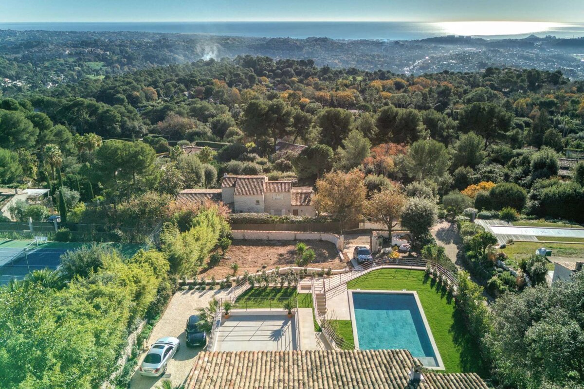 An aerial view of a house with a large pool