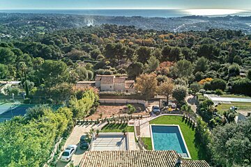 An aerial view of a house with a large pool
