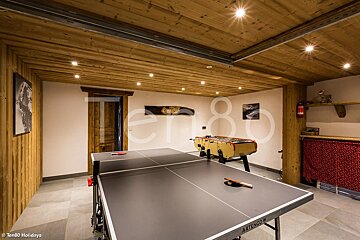 A ping pong table in a room with the number 80 on the wall