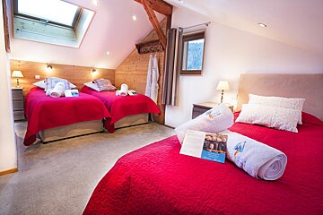 A hotel room with two beds and a book on the bed